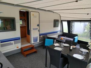 a dining room with a table and chairs and a train at Nissum Fjord Camping in Fjand Gårde