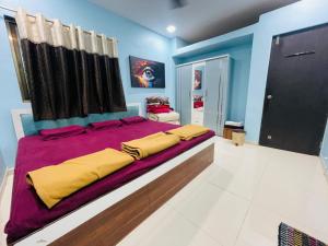 a large bedroom with a large bed with yellow sheets at NS Dosti By Glitz Cottage in Agashi