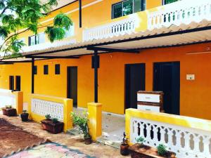 an orange house with a white fence in front of it at NS Dosti By Glitz Cottage in Agashi