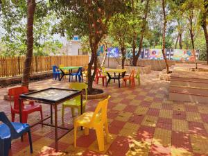 a group of tables and chairs in a park at NS Dosti By Glitz Cottage in Agashi +9 photos