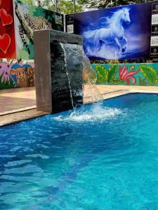 a water fountain in a pool with a mural of a horse at NS Dosti By Glitz Cottage in Agashi