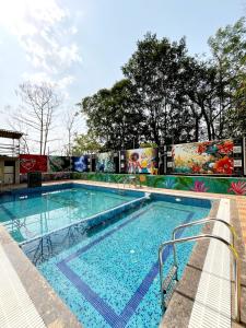 a swimming pool with a mural on the side of a building at NS Dosti By Glitz Cottage in Agashi