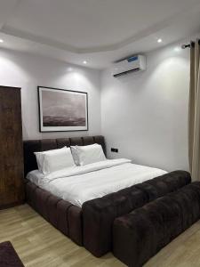 a large bed in a room with a leather couch at Raya in Lagos