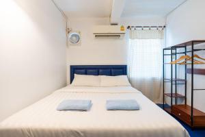 a bedroom with a bed with two towels on it at Arawana Hostel Silom in Bangkok