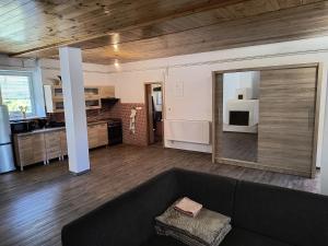 a living room with a couch and a kitchen at Volšovy Apartment in Sušice