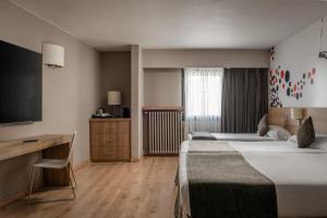 ein Hotelzimmer mit zwei Betten und einem Schreibtisch in der Unterkunft Estival Sporting in Pas de la Casa