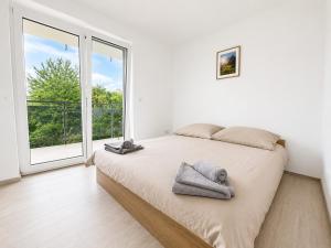 a white bedroom with a bed and a large window at TO-HAD, Modern Apartments next to U-bahn with free Wifi in Vienna