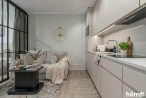 a kitchen and living room with a couch and a table at Libra Luxury AC - homfi Collection in Krakow