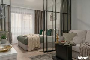 a living room with a bed and a couch at Libra Luxury AC - homfi Collection in Krakow