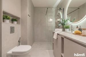 a bathroom with a toilet and a sink and a mirror at Libra Luxury AC - homfi Collection in Krakow