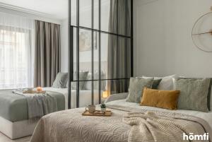 a living room with a bed and a couch at Libra Luxury AC - homfi Collection in Krakow +8 photos