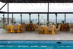 a restaurant with tables and chairs and a pool at Holiday Inn Guadalajara Select by IHG in Guadalajara