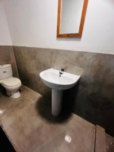 a bathroom with a sink and a toilet at Footmark Surf Stay in Pottuvil