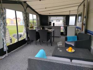 a living room with a table and chairs in a van at Nissum Fjord Camping in Fjand Gårde