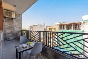 ein Balkon mit Tisch und Stühlen an einem Gebäude in der Unterkunft Hotel BNB Stays Near Golf Course Road in Gurgaon + 17 Fotos