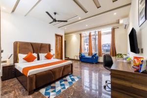 ein Schlafzimmer mit Bett, Schreibtisch und Fernseher in der Unterkunft Hotel BNB Stays Near Golf Course Road in Gurgaon
