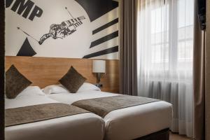 ein Hotelzimmer mit zwei Betten und einem großen Fenster in der Unterkunft Estival Sporting in Pas de la Casa