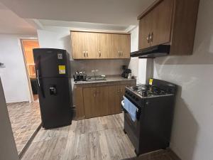 a kitchen with a black refrigerator and a stove at Apartamento amoblado Chinchiná in Chinchiná