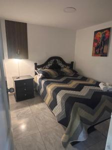 a bedroom with a bed and a table with a lamp at Apartamento amoblado Chinchiná in Chinchiná