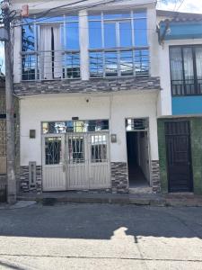 a white house with a gate and a balcony at Apartamento amoblado Chinchiná in Chinchiná