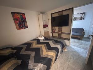 a bedroom with a bed and a flat screen tv at Apartamento amoblado Chinchiná in Chinchiná