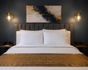 ein Schlafzimmer mit einem großen weißen Bett und zwei Lampen in der Unterkunft SOVEL Hotel in Miami