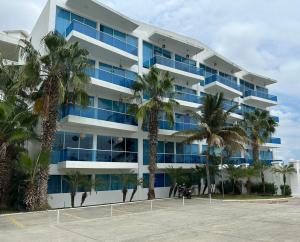 a building with palm trees in front of it at Punta Centinela - Townhouse 200 in Punta Blanca