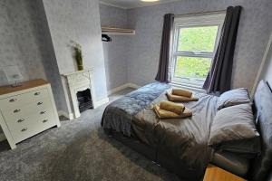 a bedroom with a bed with pillows and a window at Entire Charming Three Bedroom Seaside House With Garden - Close to Town & Beach, Ideal for Groups, Families in Sheringham