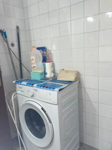 a washing machine with a bottle of milk on top of it at Appartement in Girona