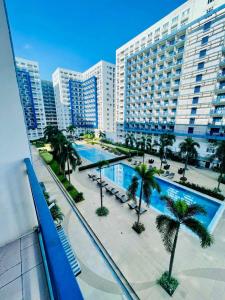 a view of a large building with a pool and palm trees at Sea Residences Sunset Point in Manila