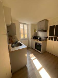 a small kitchen with a sink and a stove at L'écrin pure in Falaise