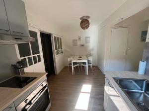 a kitchen with a table and a dining room at L'écrin pure in Falaise +1 photo