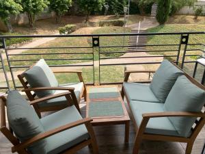 a group of chairs and tables on a balcony at L'escapade - Confort et calme in Tassin-la-Demi-Lune