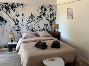 a bedroom with a bed with a flowery wall at le Studio Balnéo des Cocons de Mel in Quinssaines