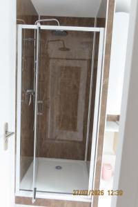 a shower with a glass door in a bathroom at Aux Ogiers in Croix