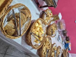 three baskets of bread and pastries on a table at Pousada dos Bandeirantes in Ouro Preto
