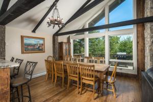 a dining room with a table and chairs and windows at Majestic Mountain Haus in Beech Mountain +44 photos