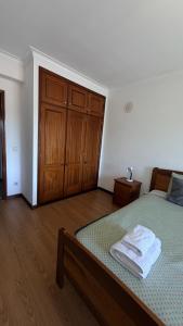 a bedroom with a bed and wooden cabinets at Quarto de Solteiro com varanda centro de Viseu in Viseu
