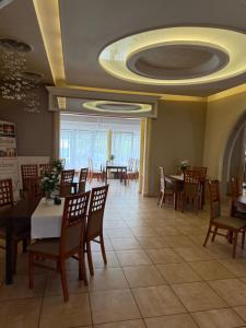 a dining room with tables and chairs and a ceiling at Hotel Mimoza in Libusza