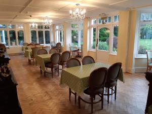 a dining room with tables and chairs and windows at Staghunters Inn Hotel in Countisbury +7 photos