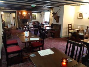 a restaurant with tables and chairs in a room at Staghunters Inn Hotel in Countisbury