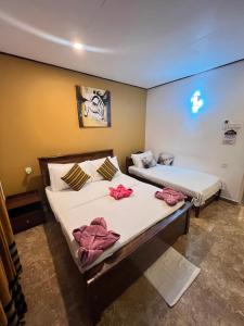 two beds in a room with towels on them at White Villa Airport Transit Hotel in Katunayaka