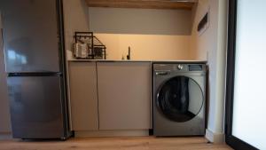 a laundry room with a washer and a refrigerator at The Circle Luxury Self Catering Studios in Potchefstroom