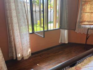 a room with two windows and a wooden floor at Moratuwa suburban oasis in Moratuwa