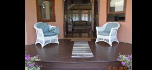 two chairs sitting on the front porch of a house at Moratuwa suburban oasis in Moratuwa