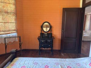 a bedroom with a mirror on a table with a bed at Moratuwa suburban oasis in Moratuwa