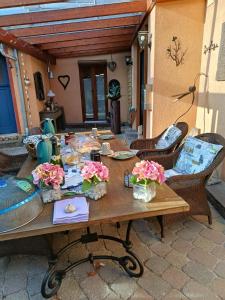 a wooden table with flowers on a patio at Ferienwohnung Camino in Jockgrim