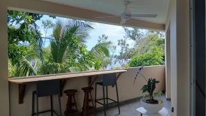 a balcony with bar stools and a large window at le Chant des vagues 1 in Saint-Philippe