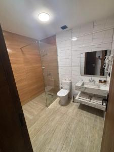 a bathroom with a shower and a toilet and a sink at Hôtel City Center in Nador