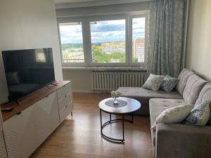 a living room with a couch and a flat screen tv at Rubinkowo Rooms Self Check-in 24h in Toruń
